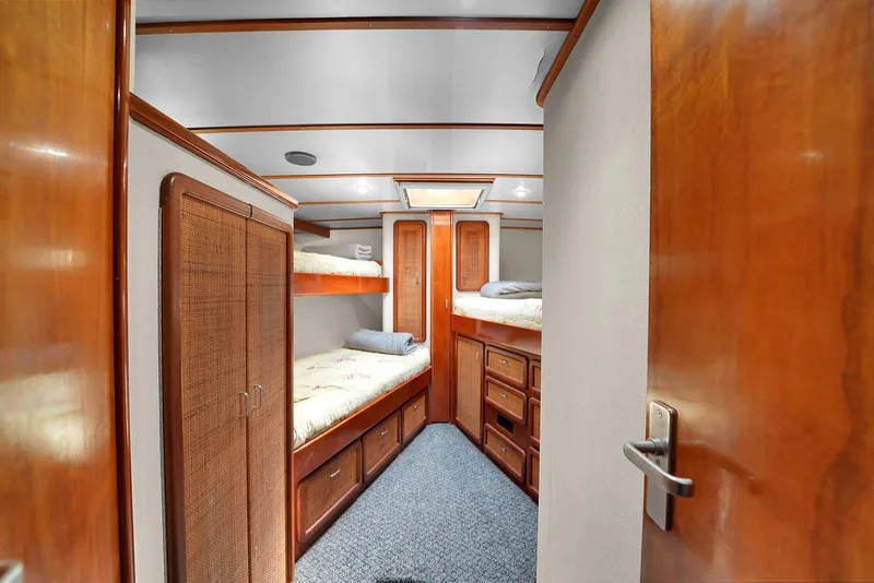 Slide: The Image of 1991 Jones-Goodell Yachtfish interior cabin with wooden bunk beds and storage. - 17