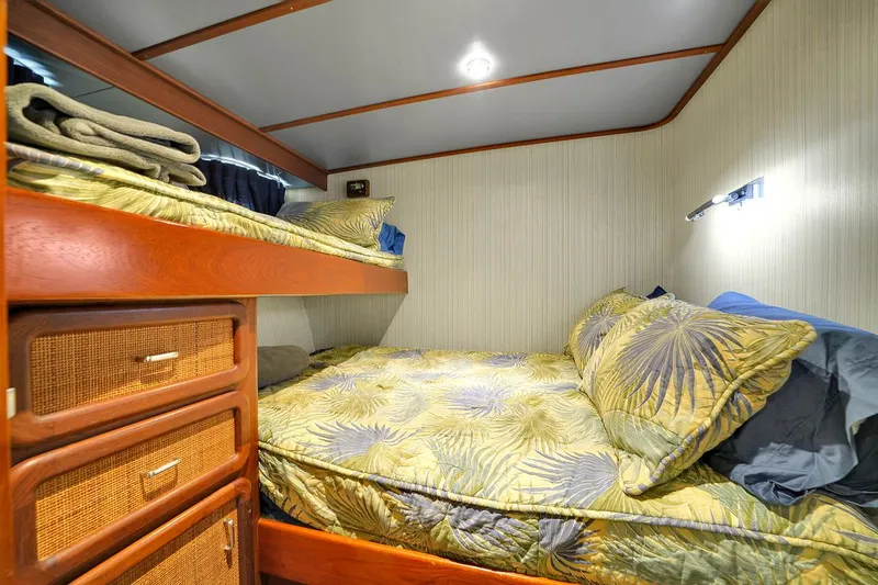 Slide: The Image of 1991 Jones-Goodell Yachtfish cozy cabin with bunk beds and tropical bedding. - 45