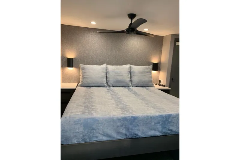 Slide: The Image of Modern bedroom with gray bedding, wall sconces, and ceiling fan, from Adonia Utopia Trip #12. - 11