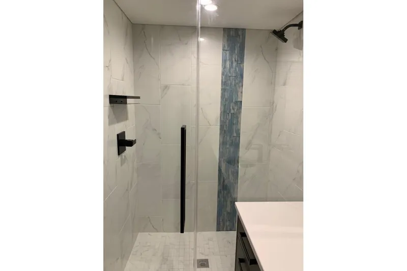 Slide: The Image of Modern bathroom shower with marble tiles and blue accent, Adonia Utopia Trip #12, 2019. - 12