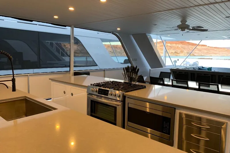 Slide: The Image of Luxurious yacht kitchen with modern appliances, featuring scenic views of water and cliffs. Adonia Utopia Trip 2019. - 16