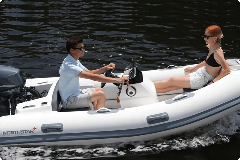 Slide: The Image of 2021 Northstar Axis 3.1 inflatable boat on water with two passengers. - 4