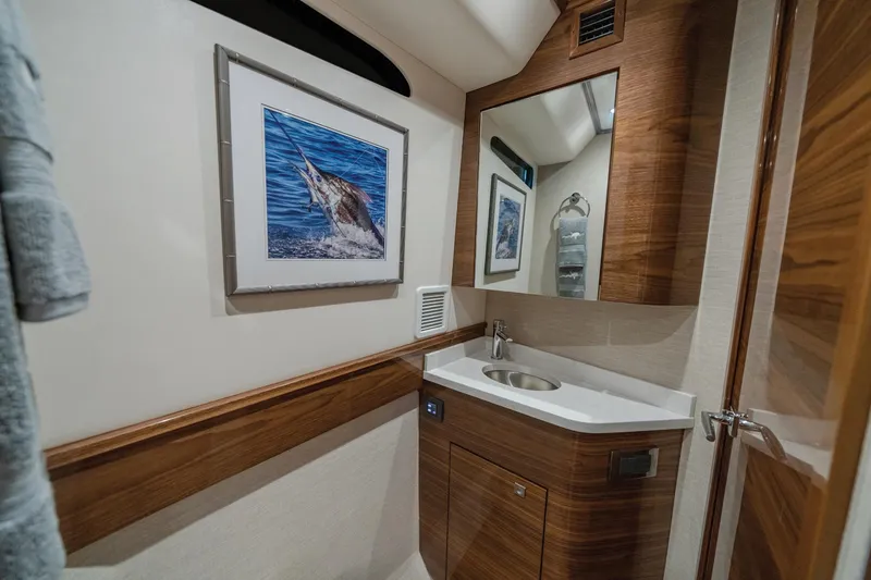 Slide: The Image of Luxurious bathroom interior of 2025 Valhalla Boatworks V-55 with wood accents and artwork. - 11