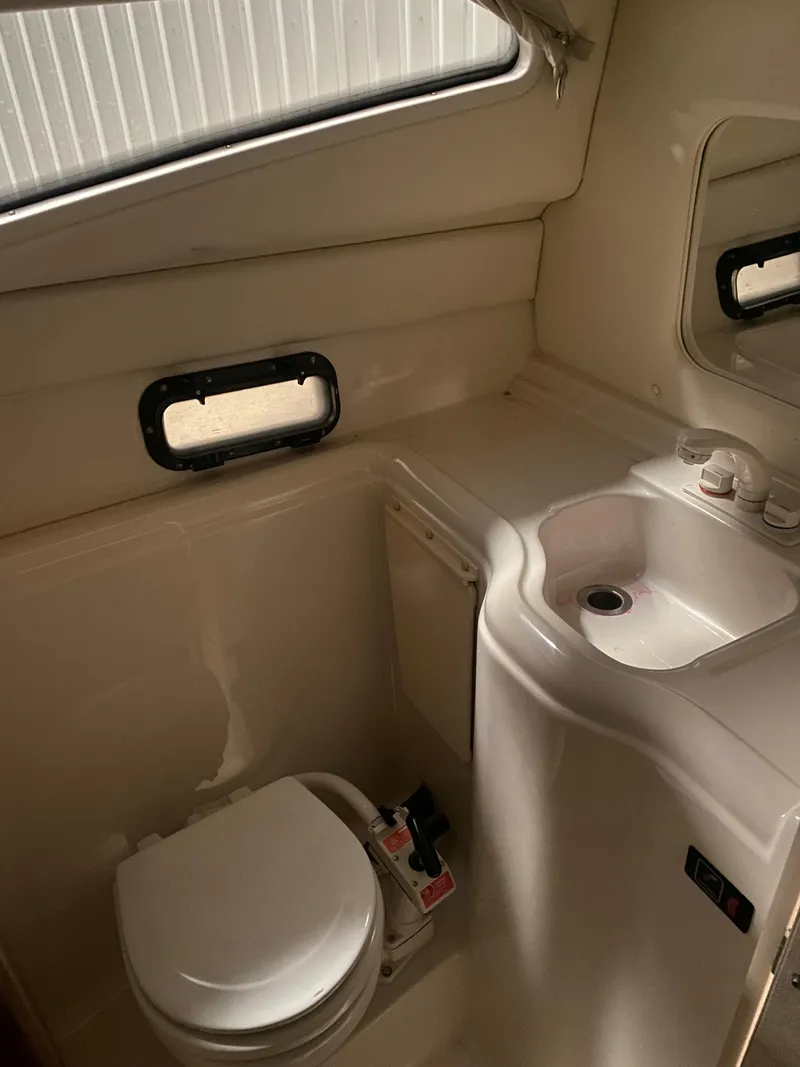 Slide: The Image of 1995 Bayliner Ciera boat bathroom with toilet, sink, and window. - 10