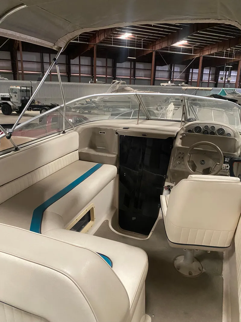 Slide: The Image of 1995 Bayliner Ciera boat interior with white seating and steering console. - 2