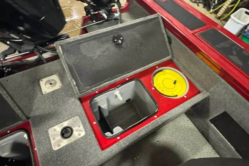 Slide: The Image of 2019 Tracker Targa 18 WT boat interior with storage compartment and fishing equipment. - 14