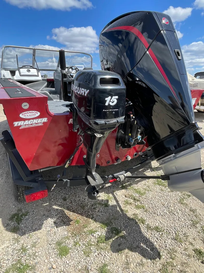 Slide: The Image of 2019 Tracker Targa 18 WT boat with dual outboard motors in a garage setting. - 5