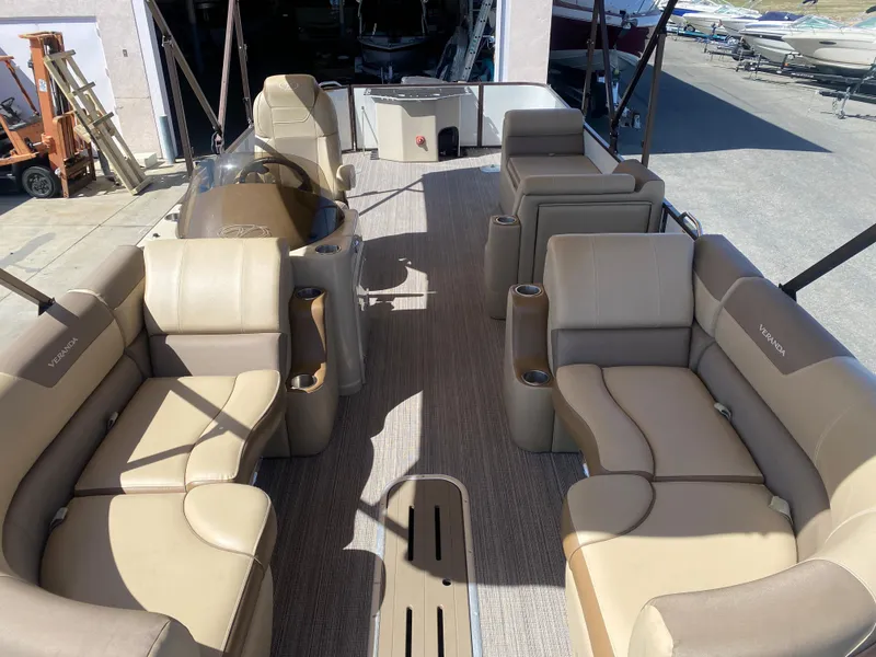 Slide: The Image of 2019 Veranda VF25F2 pontoon boat with beige seating and open deck, parked outdoors. - 9