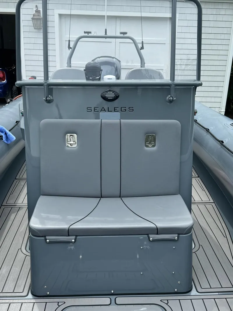 Slide: The Image of 2019 Sealegs 9M boat with gray seating and console, parked in front of a garage. - 17