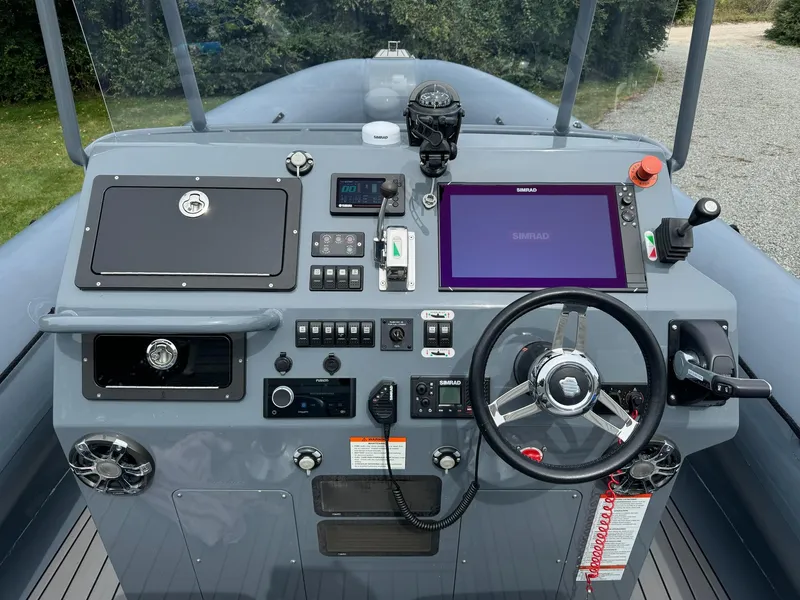 Slide: The Image of Control panel of a 2019 Sealegs 9M boat with steering wheel and navigation equipment. - 19