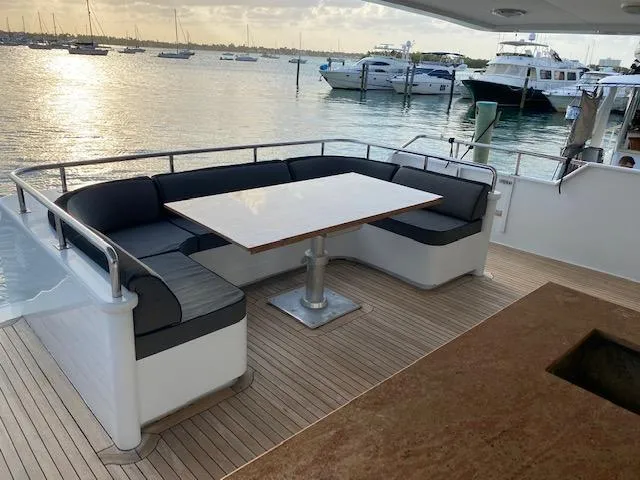 Slide: The Image of Luxurious 1990 Broward Raised Pilothouse MY yacht with elegant outdoor seating and scenic marina view. - 10