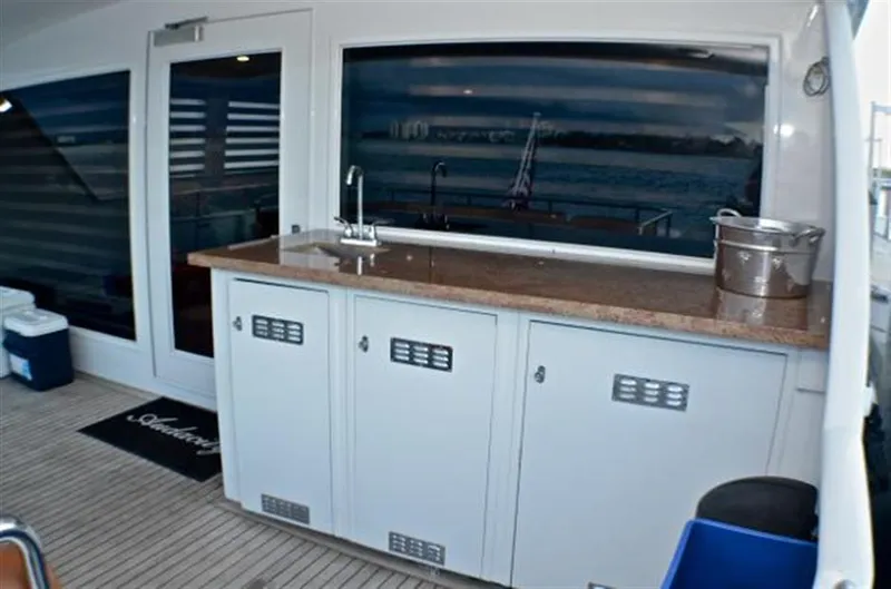 Slide: The Image of Outdoor kitchen on 1990 Broward Raised Pilothouse MY yacht with sink and storage cabinets. - 12