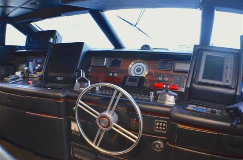 Slide: The Image of Pilothouse interior of 1990 Broward Raised Pilothouse MY yacht, featuring navigation equipment and steering wheel. - 13