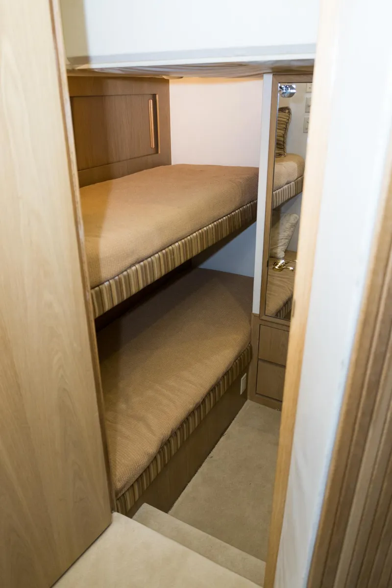 Slide: The Image of Bunk beds in 1997 Hatteras 65 Convertible yacht cabin, featuring wooden interior design. - 15