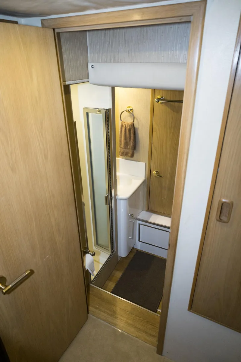 Slide: The Image of Bathroom interior of 1997 Hatteras 65 Convertible yacht, featuring wood accents and compact design. - 16