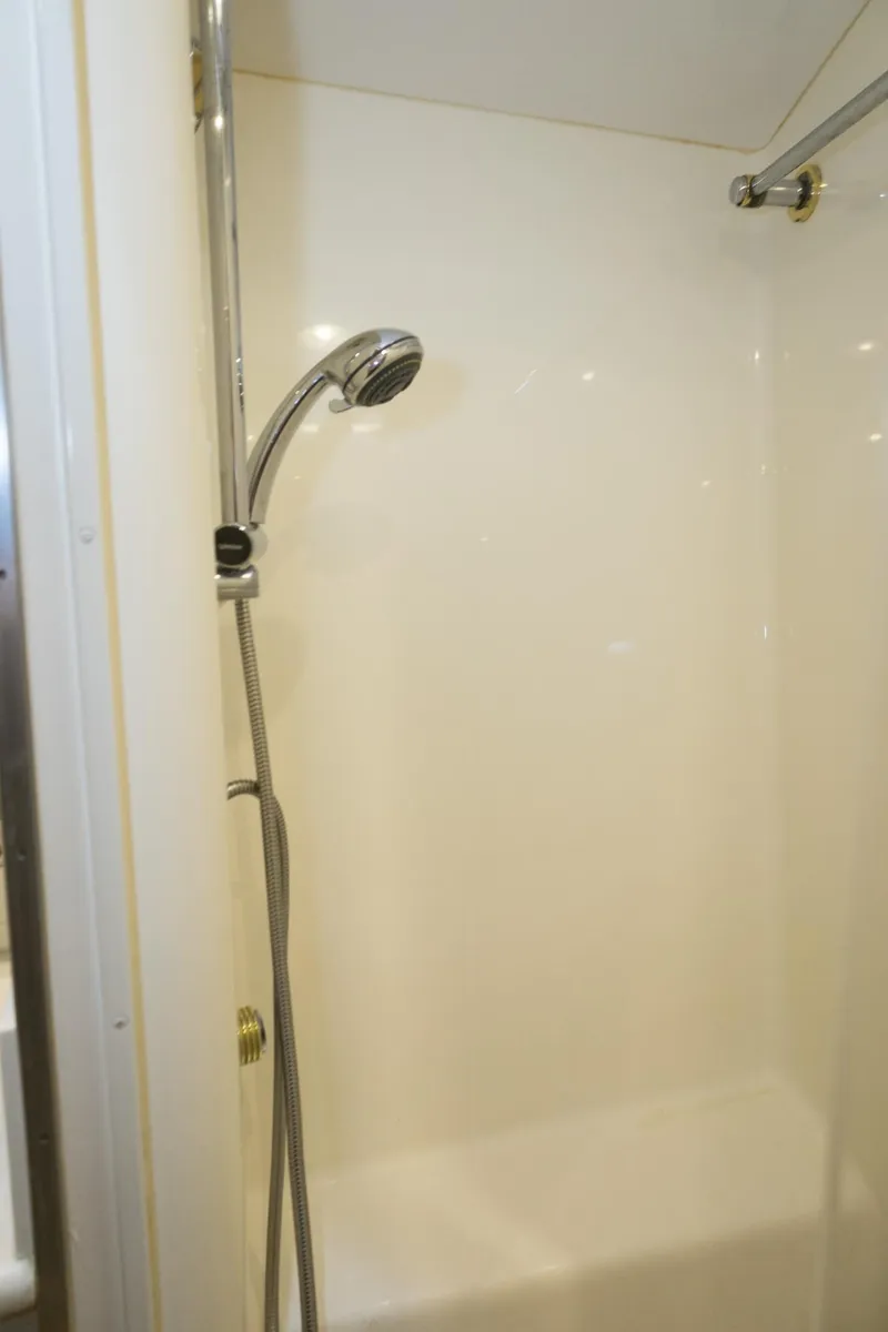 Slide: The Image of Shower area in 1997 Hatteras 65 Convertible yacht, featuring a handheld showerhead. - 22