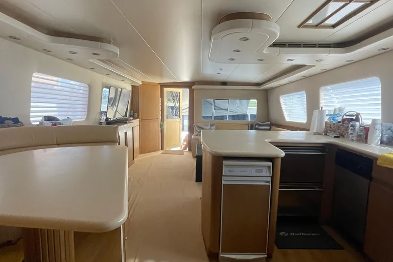 Slide: The Image of Interior of 1997 Hatteras 65 Convertible yacht, featuring spacious kitchen and dining area. - 4