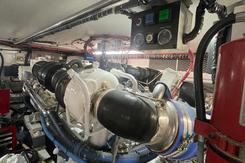 Slide: The Image of Engine room of 1997 Hatteras 65 Convertible yacht, featuring complex machinery and control panels. - 45