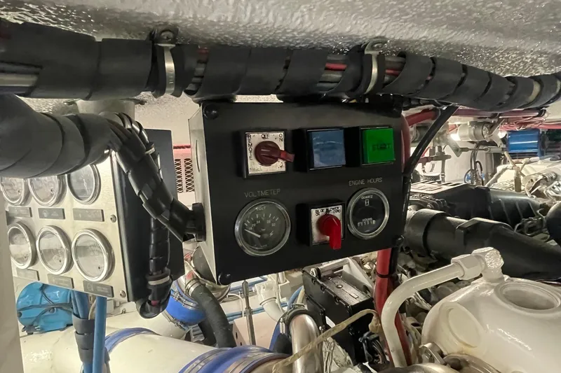 Slide: The Image of Engine room controls of a 1997 Hatteras 65 Convertible yacht, featuring gauges and wiring. - 52