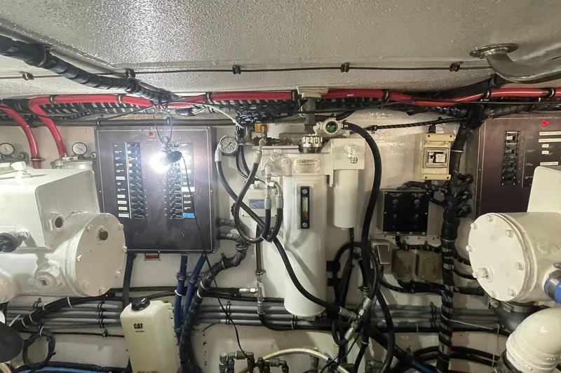 Slide: The Image of Engine room of 1997 Hatteras 65 Convertible yacht with control panels and wiring. - 53