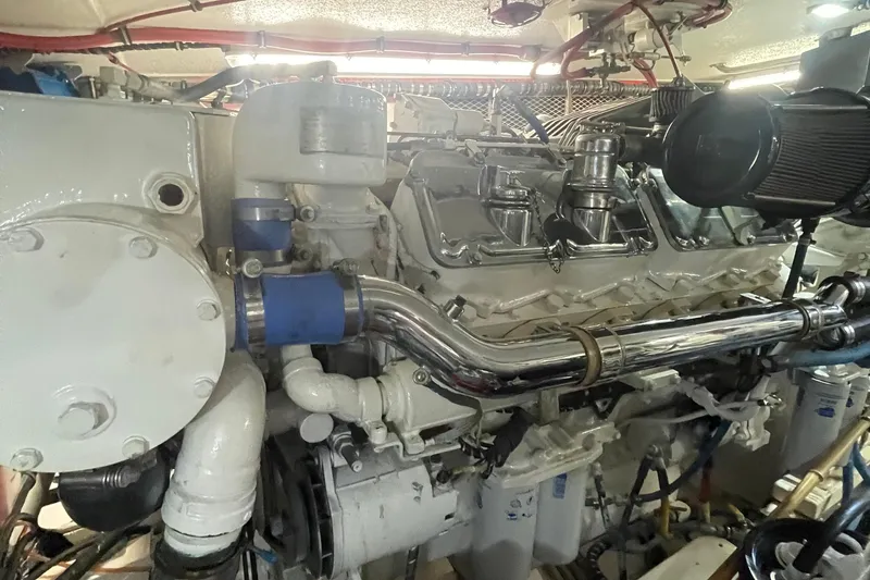 Slide: The Image of Engine room of a 1997 Hatteras 65 Convertible yacht, showcasing mechanical components. - 56