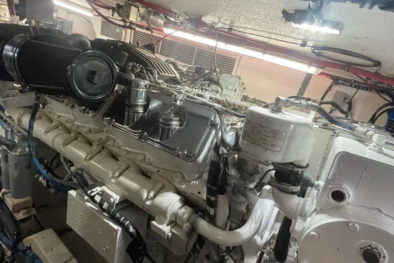 Slide: The Image of Engine room of a 1997 Hatteras 65 Convertible yacht, showcasing detailed machinery. - 57
