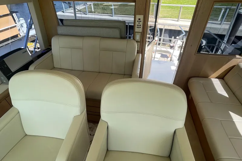 Slide: The Image of Interior of 1997 Hatteras 65 Convertible yacht with beige seating and wood accents. - 64