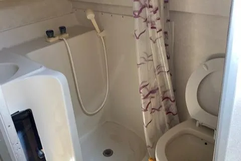 Slide: The Image of 1990 Silverton 34 Express boat bathroom with shower and toilet. - 15