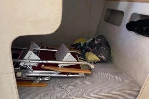 Slide: The Image of Interior cabin of a 1990 Silverton 34 Express boat with folded chairs and bedding. - 21