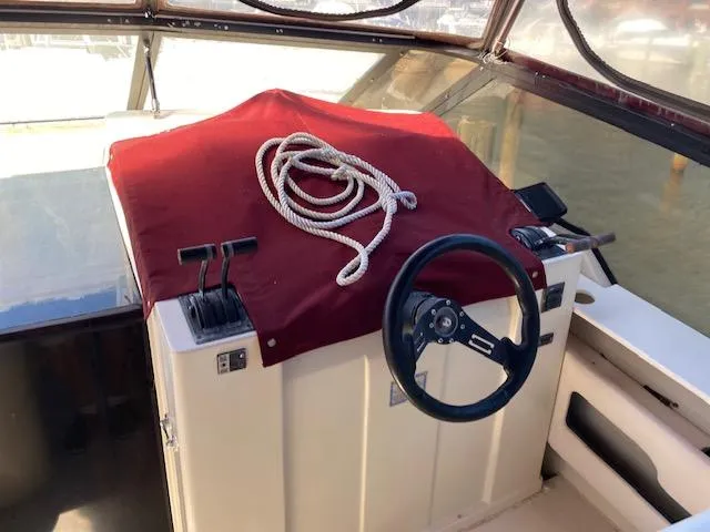 Slide: The Image of 1990 Silverton 34 Express boat helm with steering wheel and controls. - 8