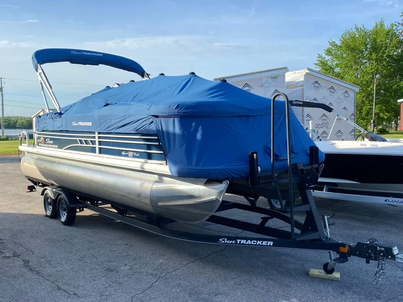 Slide: The Image of 2020 Sun Tracker SportFish 22 DLX pontoon boat with blue cover on trailer. - 19