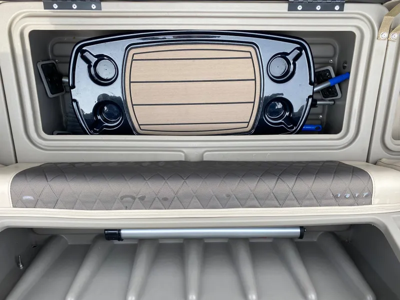 Slide: The Image of 2020 Sun Tracker SportFish 22 DLX storage compartment with integrated cup holders and padded seating. - 22