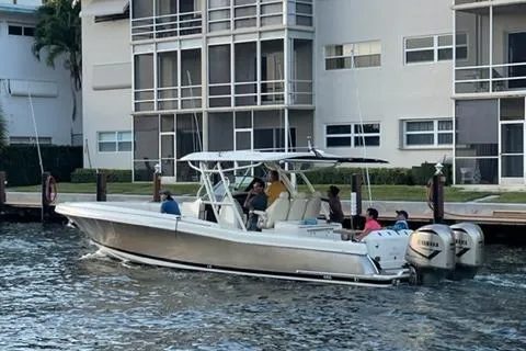The Image of 2017 Chris-Craft 35 Catalina boat cruising near waterfront apartments. - 1