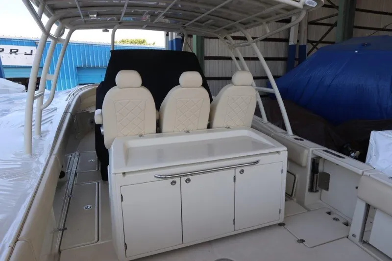 Slide: The Image of 2017 Chris-Craft 35 Catalina boat interior with three white seats and storage cabinet. - 10