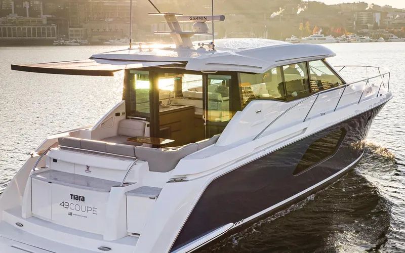 Slide: The Image of 2023 Tiara Yachts 49 COUPE cruising on a sunlit waterway. - 13