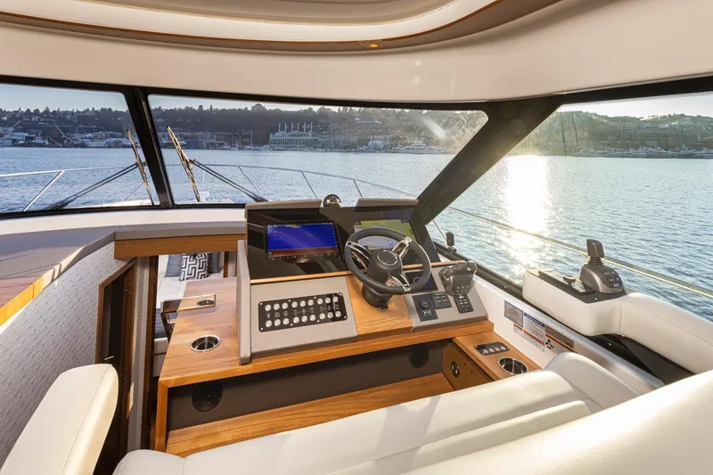 Slide: The Image of 2023 Tiara Yachts 49 COUPE helm with modern controls and scenic water view. - 27