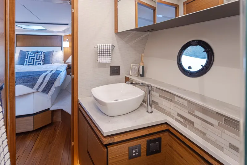 Slide: The Image of Luxurious bathroom in 2023 Tiara Yachts 49 COUPE with modern sink and porthole window. - 35