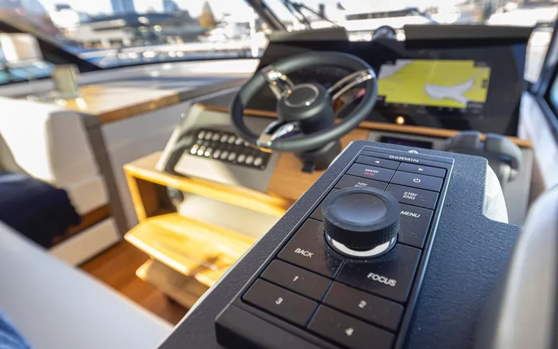 Slide: The Image of 2023 Tiara Yachts 49 COUPE helm with advanced navigation controls and steering wheel. - 47