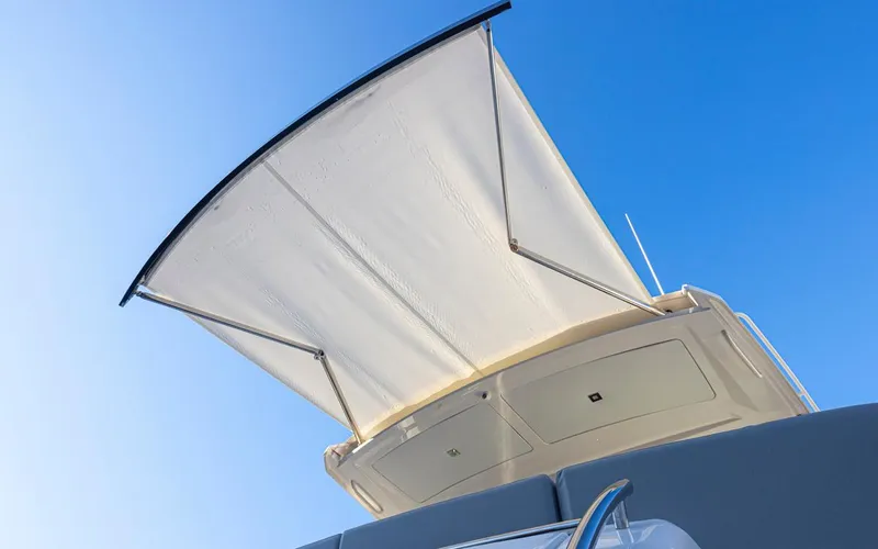 Slide: The Image of 2023 Tiara Yachts 49 COUPE with extended sunshade against clear blue sky. - 49