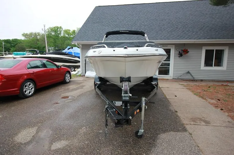 Slide: The Image of 2015 Crownline 21 SS boat on trailer in driveway. - 2