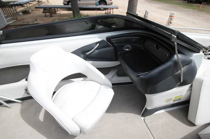 Slide: The Image of 2015 Crownline 21 SS boat interior with white seating and black dashboard. - 9