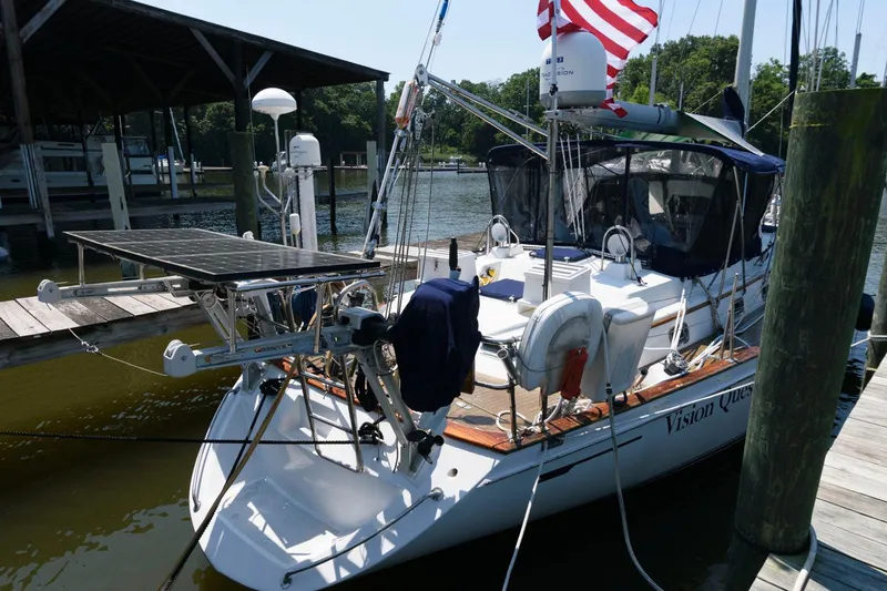 Slide: The Image of 1988 Tayana 52 sailboat docked with solar panels and American flag. - 16