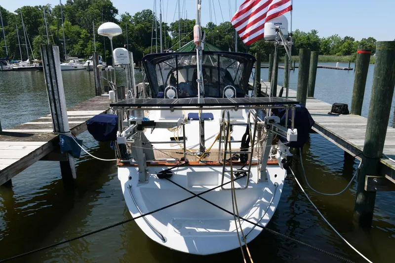 Slide: The Image of 1988 Tayana 52 sailboat docked at marina with American flag. - 18