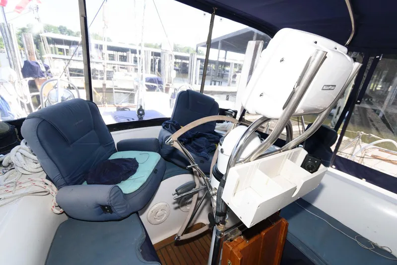 Slide: The Image of Cockpit of 1988 Tayana 52 sailboat with blue seating and navigation equipment. - 19