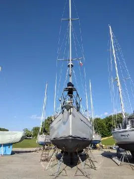 Slide: The Image of 1988 Tayana 52 sailboat on dry dock under clear blue sky. - 27