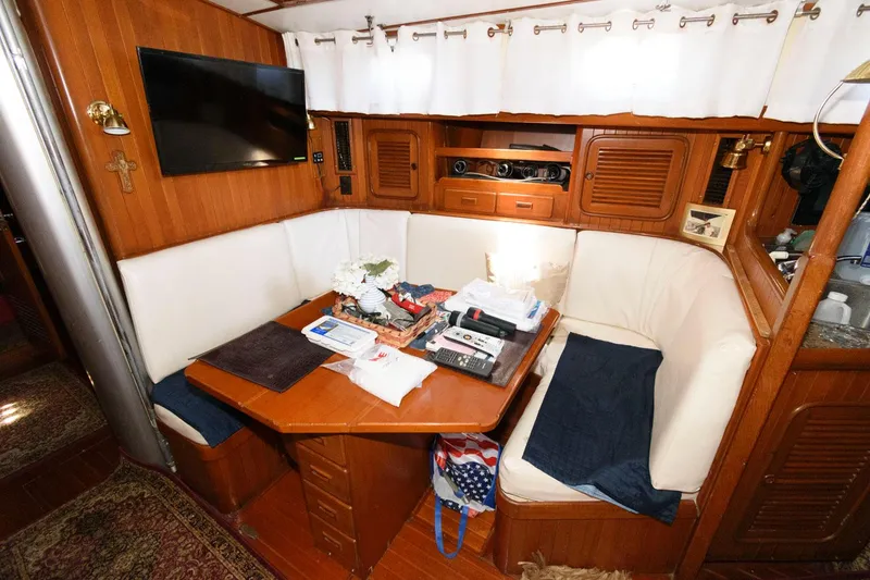 Slide: The Image of Interior of 1988 Tayana 52 sailboat with cozy dining area and wooden furnishings. - 29