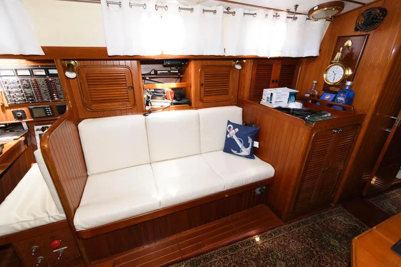 Slide: The Image of Interior of 1988 Tayana 52 yacht with white cushioned seating and nautical decor. - 30