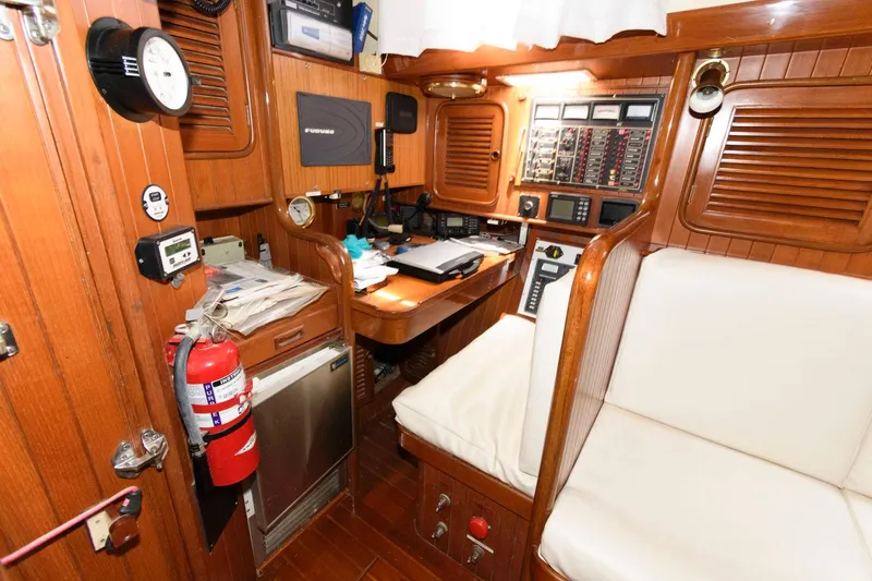Slide: The Image of Navigation station inside 1988 Tayana 52 sailboat with wooden interior and navigation equipment. - 31