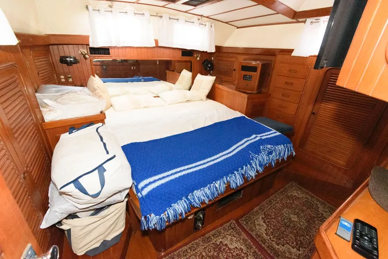 Slide: The Image of Cozy cabin interior of 1988 Tayana 52 yacht with wooden furnishings and blue blanket. - 33