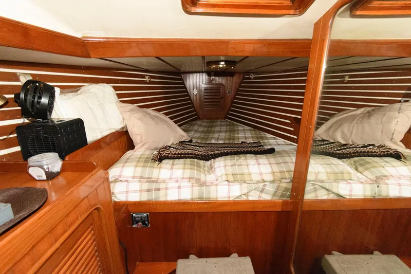 Slide: The Image of Cozy cabin interior of 1988 Tayana 52 sailboat with wooden paneling and plaid bedding. - 37